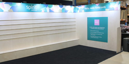 Spirit Publishing stand shell with illuminated header and empty shelving before merchandising