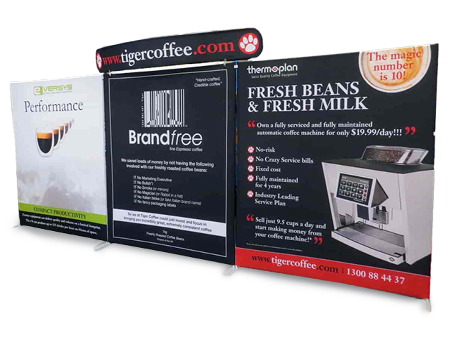 Freestanding fabric display wall with three printed panels and a curved header sign for a coffee machine supplier